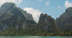 Jagged limestone mountains rising from a turquoise lake in Khao Sok, Thailand